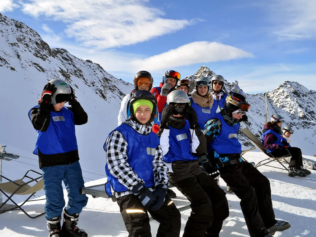 Jugendliche machen auf Liegestühlen an der Bergstation Pause.
